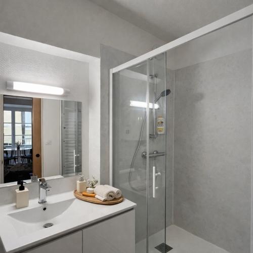 a bathroom with a glass shower and a sink at L'Âtre Angevin - cheminée d'époque - Doutre in Angers