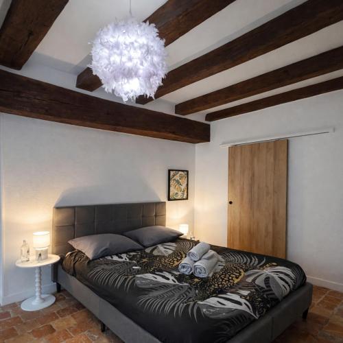 a bedroom with a large bed and a chandelier at L'Âtre Angevin - cheminée d'époque - Doutre in Angers