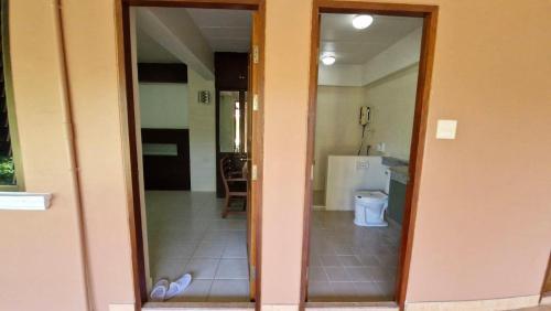 a door to a bathroom with a toilet in a room at Nature's Hideaway Homestay in Ban Lam Thong Lang