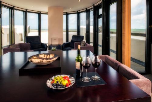 a dining room with a table with a bowl of fruit and wine glasses at Roch Castle in Roch