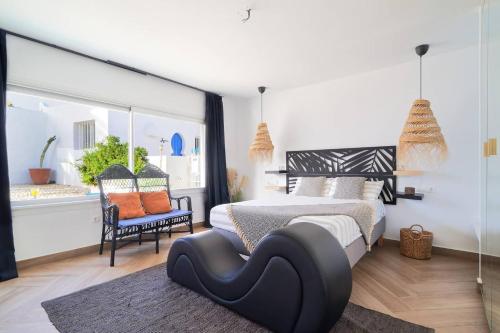 a bedroom with a black and white bed and a window at Riad Salt Pool Bliss Apartamentos in Torremolinos