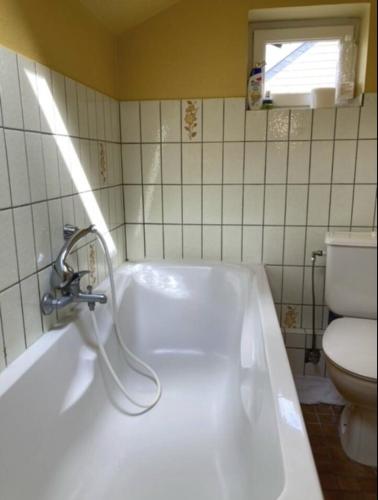 a white bath tub in a bathroom with a toilet at Le chant des sirènes in Mettet