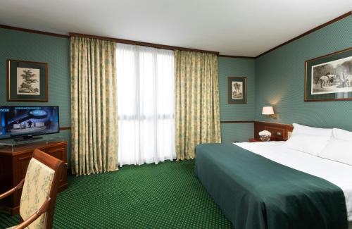 a hotel room with a bed and a television at Leonardo Hotel Milan City Center in Milan