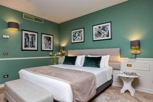 a bedroom with a large bed and green walls at Leonardo Hotel Milan City Center in Milan