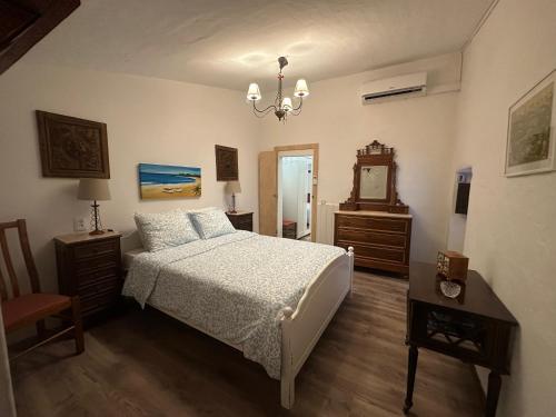 a bedroom with a bed and a table and a mirror at Refúgio Alentejano in Estremoz