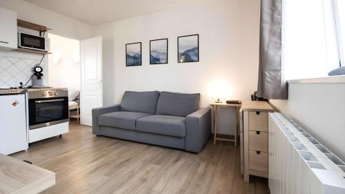 a living room with a couch and a kitchen at T2 Calme proche de la citadelle in Arras