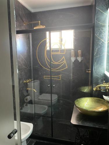 a bathroom with a glass shower with a toilet and a sink at Castelvi casa boutique in Saladillo