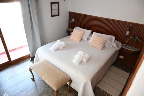 a bedroom with a large white bed with two pillows at Castelvi casa boutique in Saladillo
