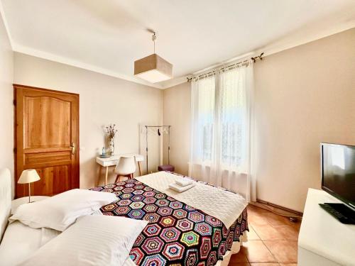 a bedroom with two beds and a tv in it at La Maison De Maria in Folembray