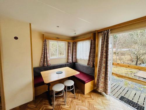 a tiny house with a bench and a table and stools at Camping L'Amandier in Gigors