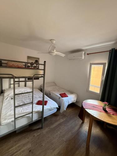 two bunk beds in a room with a table at Casa Alicante Central Apartment with AC 4th floor no elevator in Alicante