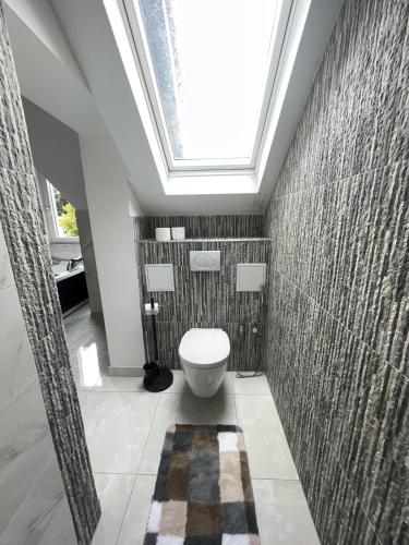 a bathroom with a toilet and a skylight at Stylish spacious residence in Düsseldorf in Düsseldorf