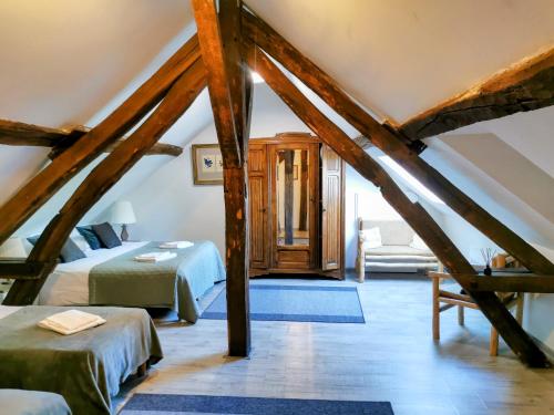 a attic bedroom with a bed and a couch at La Longère du Sallay in Saincaize-Meauce