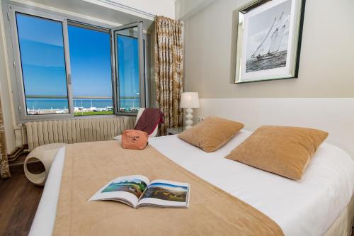 a hotel room with two beds with books on them at Hotel Aguado in Dieppe
