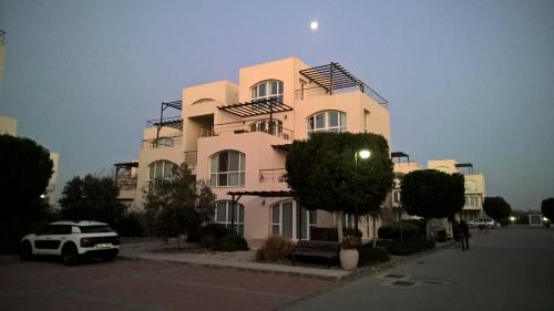 a building with a car parked in front of it at Aphrodite Beachfront Penthouse Apartment in Ghaziveran