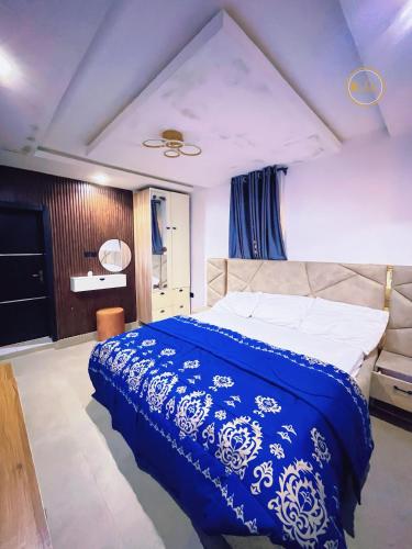 a bedroom with a bed with a blue and white blanket at Shelve Apartments in Aja