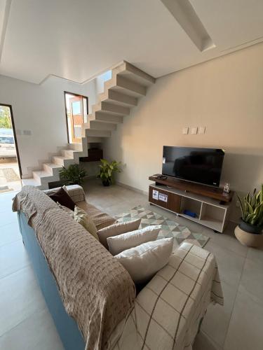 a living room with a couch and a tv at Casa Massa in Marechal Deodoro