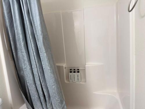 a shower with a gray shower curtain in a bathroom at Historic Downtown McKinney 3BR in McKinney