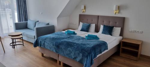 a bedroom with a large bed with a blue blanket at Villa LeLux in Mikołajki