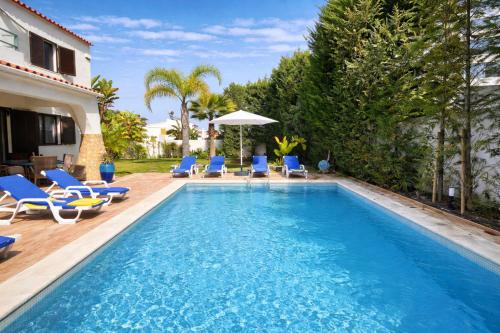 a swimming pool with chairs and a house at Golfinho - Private Pool - 10 Guests - Albufeira in Albufeira