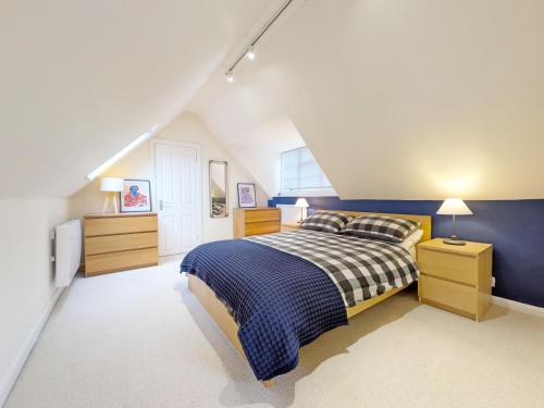 a bedroom with a bed and a blue wall at Fewhurst Cottage - Billingshurst in Billingshurst