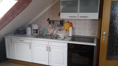 a kitchen with a sink and a stove at Ferienwohnung M. Lemmermeyer in Neumagen-Dhron