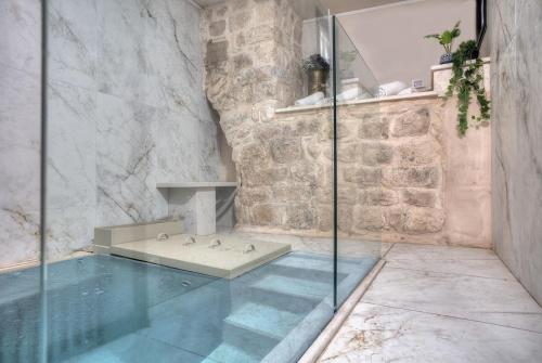 a bathroom with a tub and a glass shower at Golden Estate - גולדן אסטייט in Safed