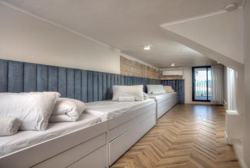 a room with two beds with white pillows at Golden Estate - גולדן אסטייט in Safed