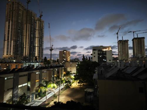 a city skyline at night with tall buildings at Small cozy room in a duplex in Bat Yam