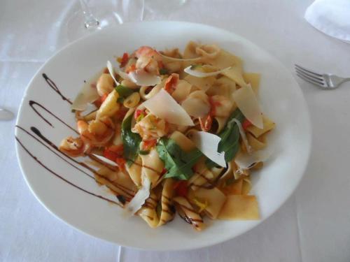 a plate of pasta with shrimp and vegetables on a table at Wald Cafe in Simbach am Inn