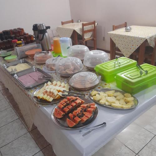 a table with several plates of food on it at Village Hotel in São Borja