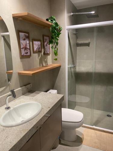 a bathroom with a toilet and a sink and a shower at Beach Class Verano 01 A in Ipojuca