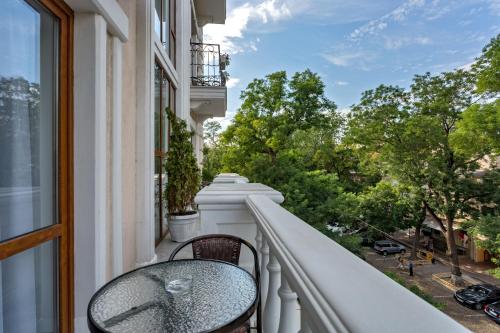 a balcony with a table and a view of trees at Boutique Hotel California in Odesa