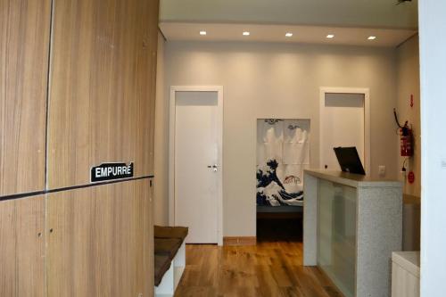 a room with a office with a sign on the wall at Nihon Cápsula Hotel in Florianópolis