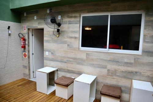 a room with two stools and a wall with a window at Nihon Cápsula Hotel in Florianópolis