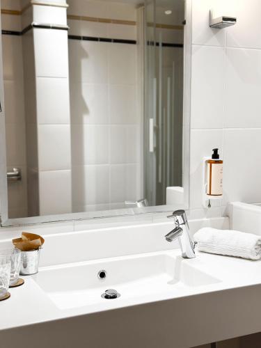 a bathroom with a sink and a large mirror at Mercure Toulouse Centre Wilson Capitole in Toulouse