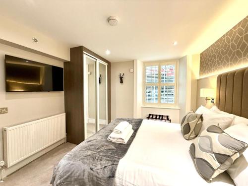 a bedroom with a large white bed and a television at Ultra Modern, Stylish Apartment Next To Princes St in Edinburgh