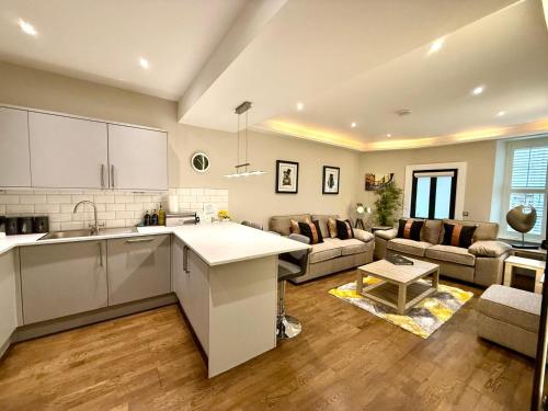 an open kitchen and living room with a couch at Ultra Modern, Stylish Apartment Next To Princes St in Edinburgh