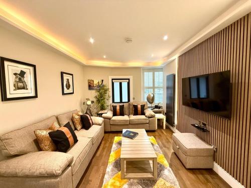 a living room with a couch and a tv at Ultra Modern, Stylish Apartment Next To Princes St in Edinburgh