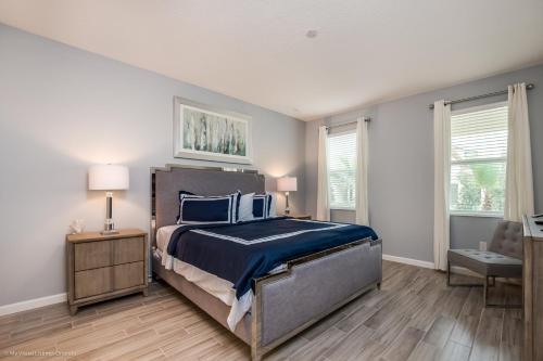 a bedroom with a bed with blue sheets and blue pillows at 10Br Retreat With Private Pool & Spa in Kissimmee