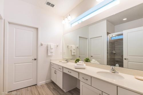 a bathroom with a sink and a large mirror at 10Br Retreat With Private Pool & Spa in Kissimmee