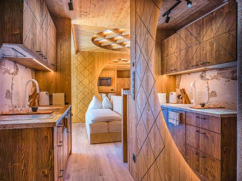 a kitchen with wooden cabinets and a couch in a room at Luxury Chalet Strachan - Jacuzzi and Sauna in Ždiar