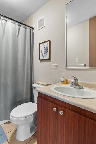 a bathroom with a toilet and a sink and a mirror at Beachfront Aquatika Resort- Style-Pools & Ocean in Rio Grande