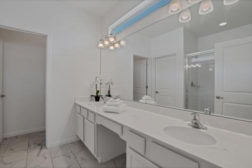 a white bathroom with a sink and a large mirror at Ev2613 - Grand Horizon Manor in Kissimmee