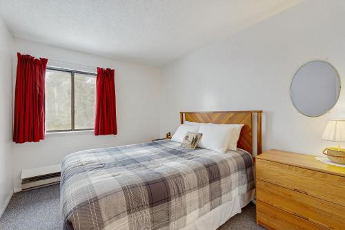 a bedroom with a bed with red curtains and a mirror at Mad House in Waterville Valley