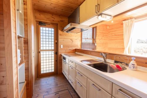 a kitchen in a log cabin with a sink at ふじのわ in Fujikawaguchiko