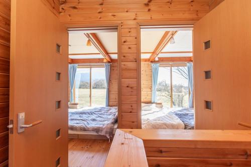 a log cabin with a room with two beds at ふじのわ in Fujikawaguchiko
