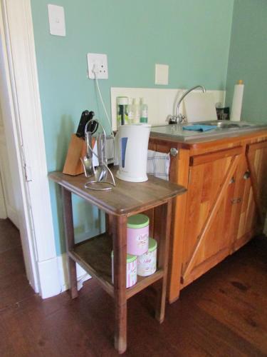 a kitchen counter with a sink and a table at Absolute Leisure Cottages in Machadodorp