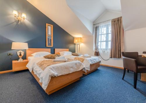 ein Hotelzimmer mit zwei Betten und einem Schreibtisch in der Unterkunft GARNI HOTEL ATRIUM in Nikšić