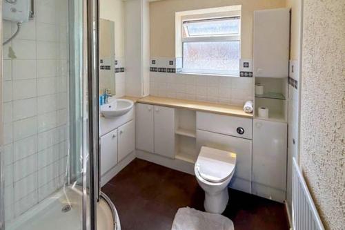 a bathroom with a toilet and a sink and a shower at House Sleeps 5 - WiFi & Tv in Luton